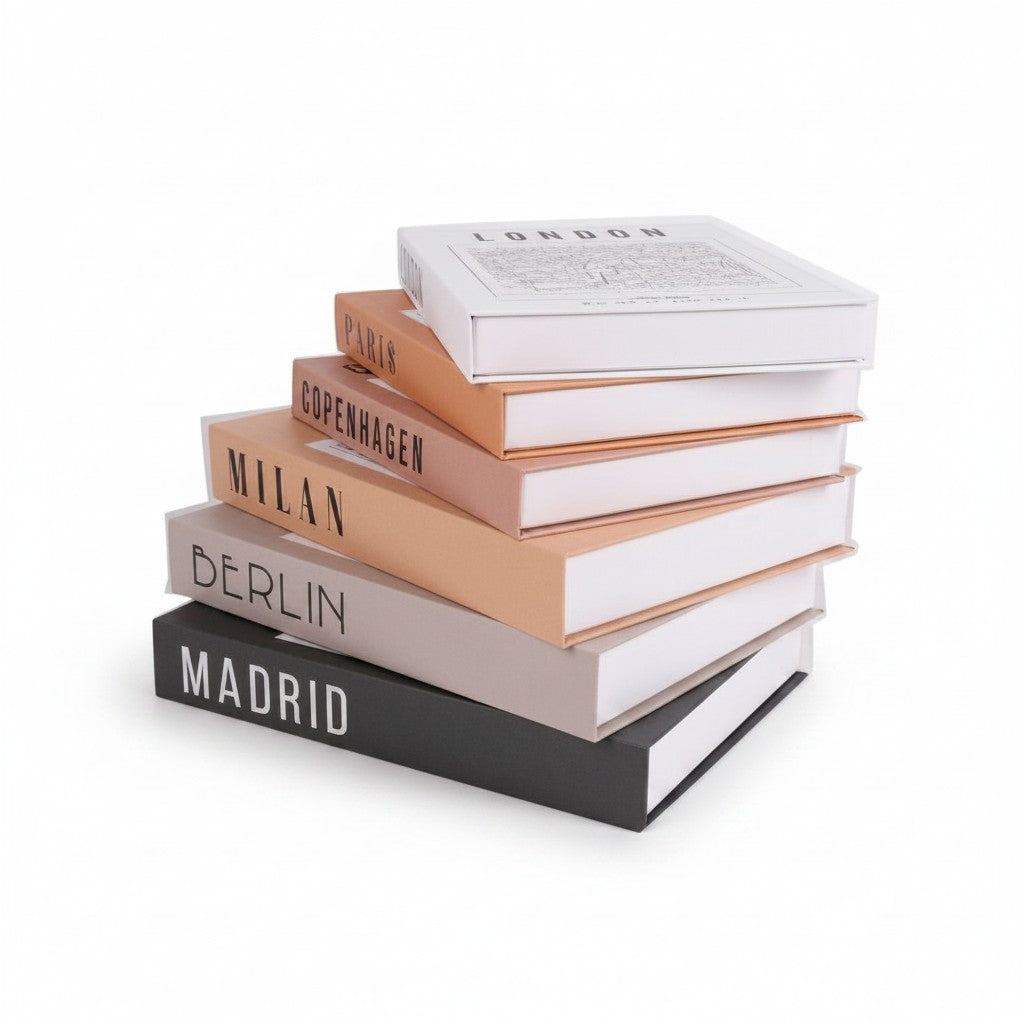 Pila de cajas decorativas WISHFUL con diseño de libro falso en tonos neutros y nombres de ciudades europeas