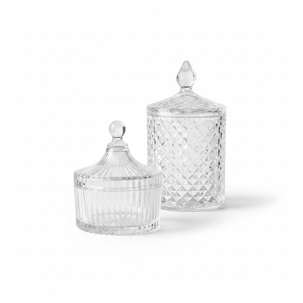 Dos carameleras de cristal transparente WISHFUL con diseños labrados y tapas decorativas sobre fondo blanco